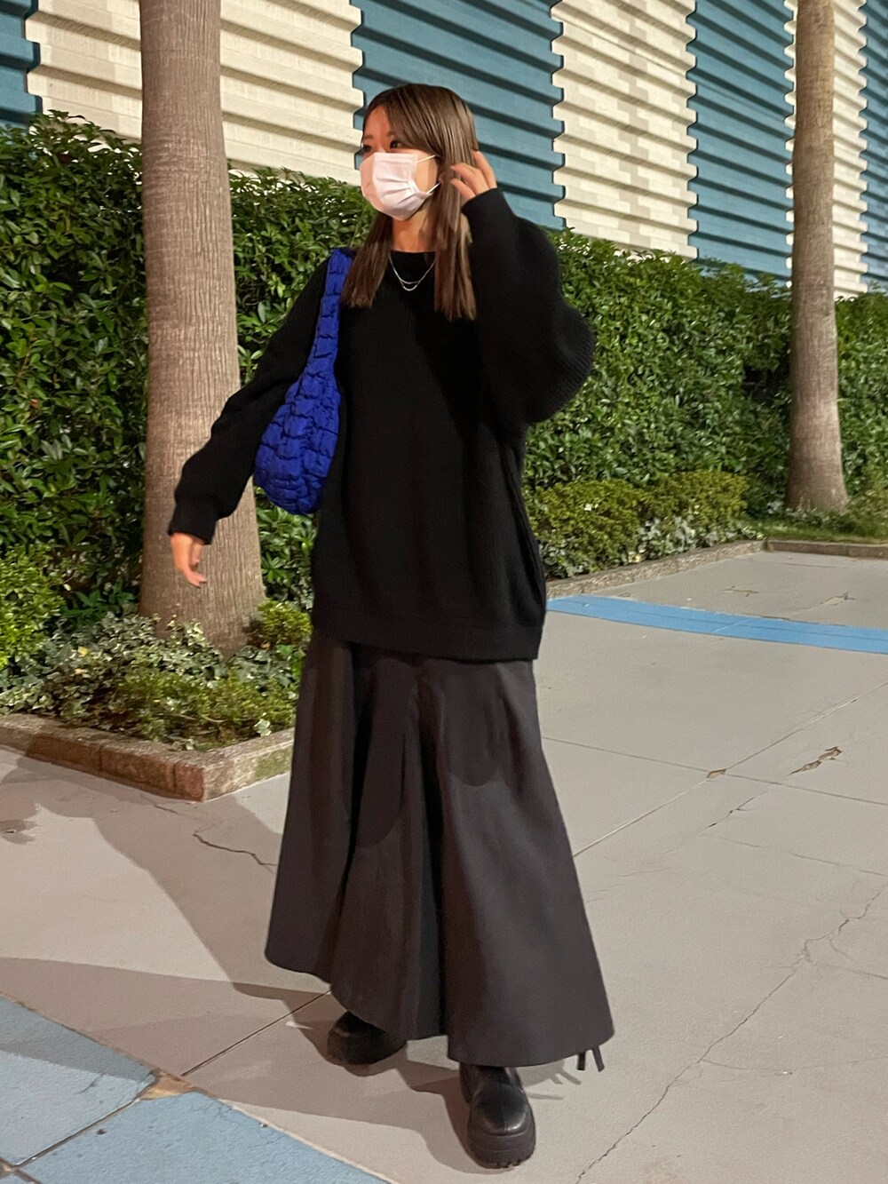 ブラック系のニット/セーター、ブラック系のワンピース、ブルー系のバッグを着用したレディースの秋コーディネートの2枚目の写真