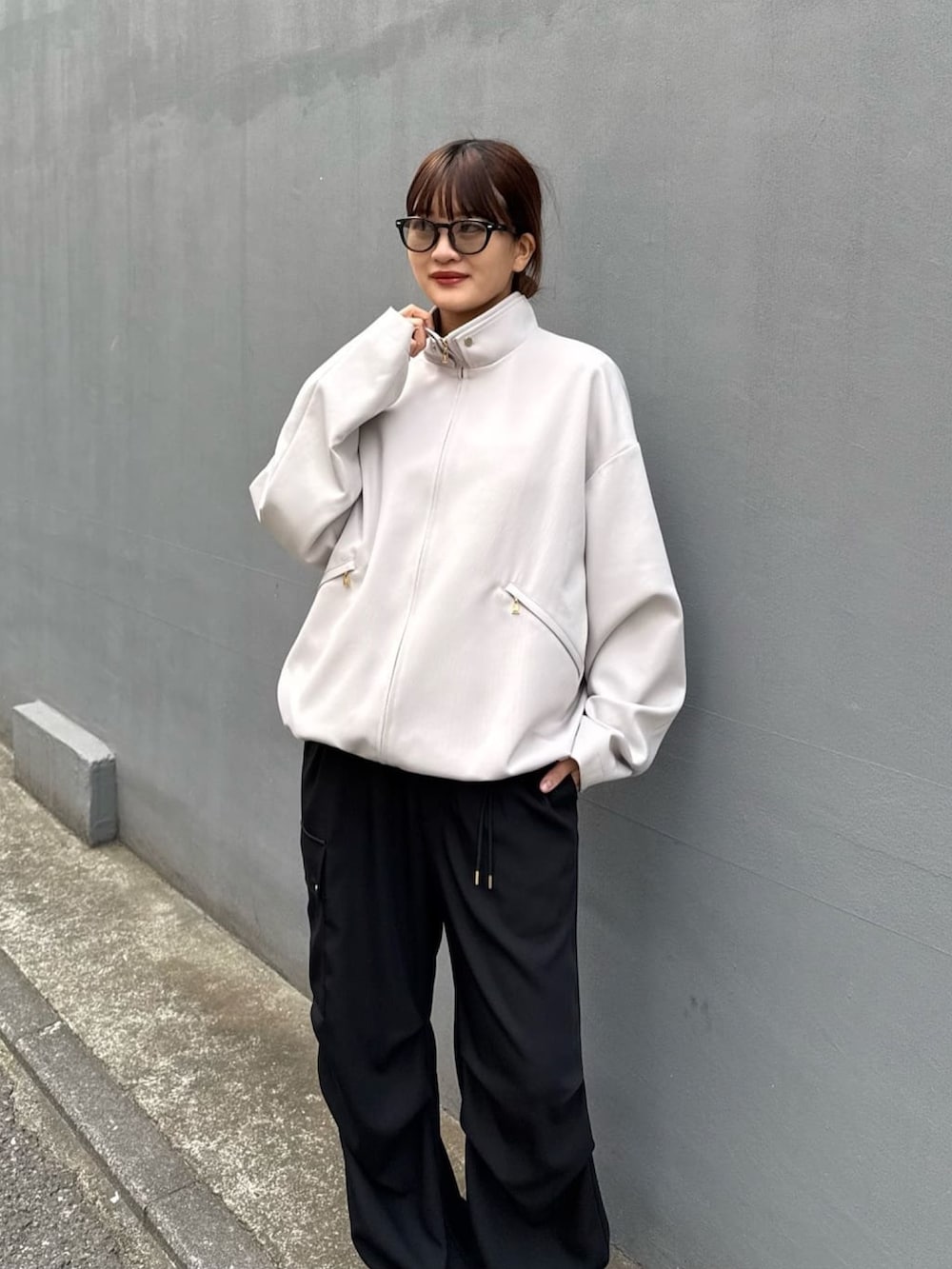 グレー系のブルゾン、ホワイト系のカーゴパンツを着用したレディースの冬コーディネートの9枚目の写真