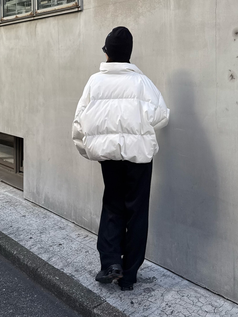 ホワイト系のダウンジャケット/コート、ブラック系のスラックス、ブラック系のベルトを着用したレディースの秋コーディネートの4枚目の写真