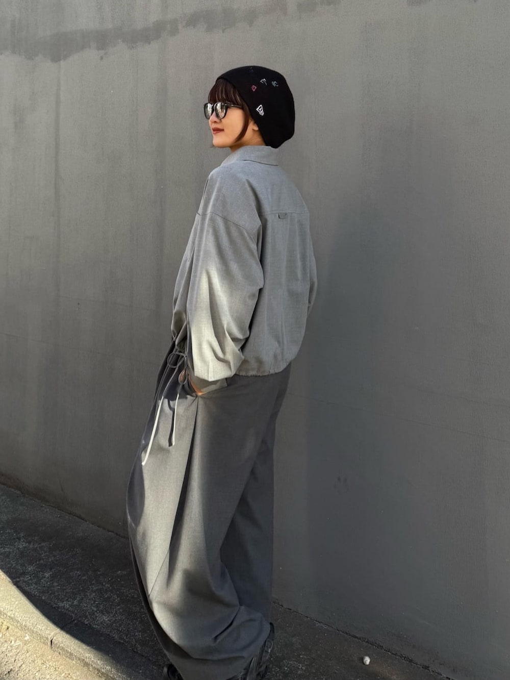 グレー系のスラックス、グレー系のシャツ/ブラウス、ブラック系のサングラスを着用したレディースの冬コーディネートの7枚目の写真