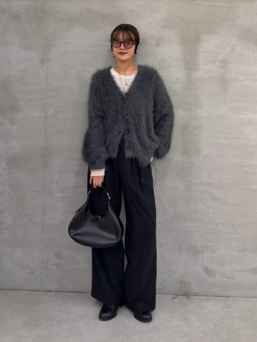 グレー系のカーディガン/ボレロ、ホワイト系のニット/セーター、ブラック系のスラックスを着用したレディースの秋コーディネートの5枚目の写真