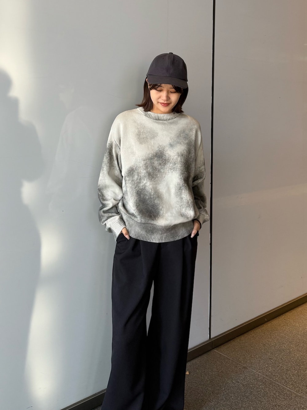 ホワイト系のニット/セーター、ブラック系のスラックスを着用したレディースの冬コーディネートの3枚目の写真