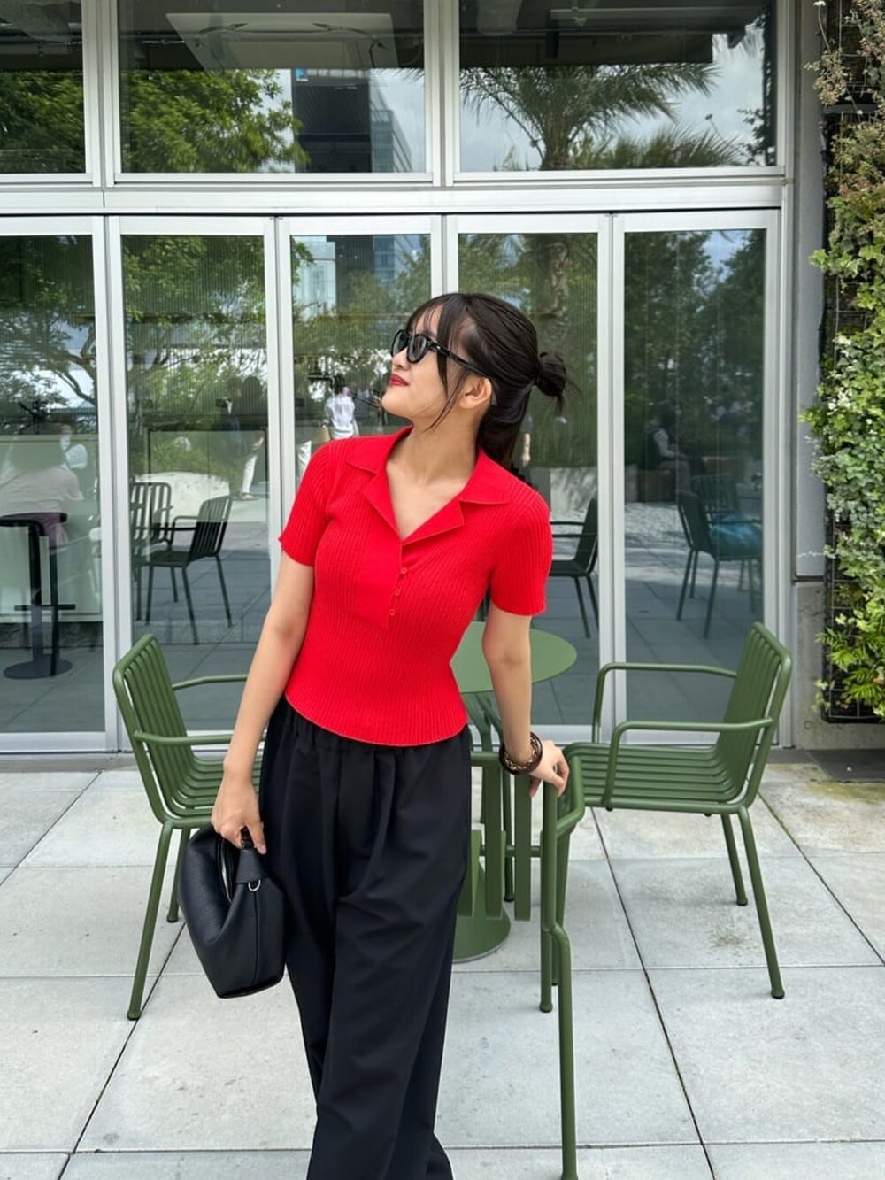 レッド系のニット/セーター、グレー系のパンツ、グレー系のサングラスを着用したレディースの夏コーディネートの2枚目の写真