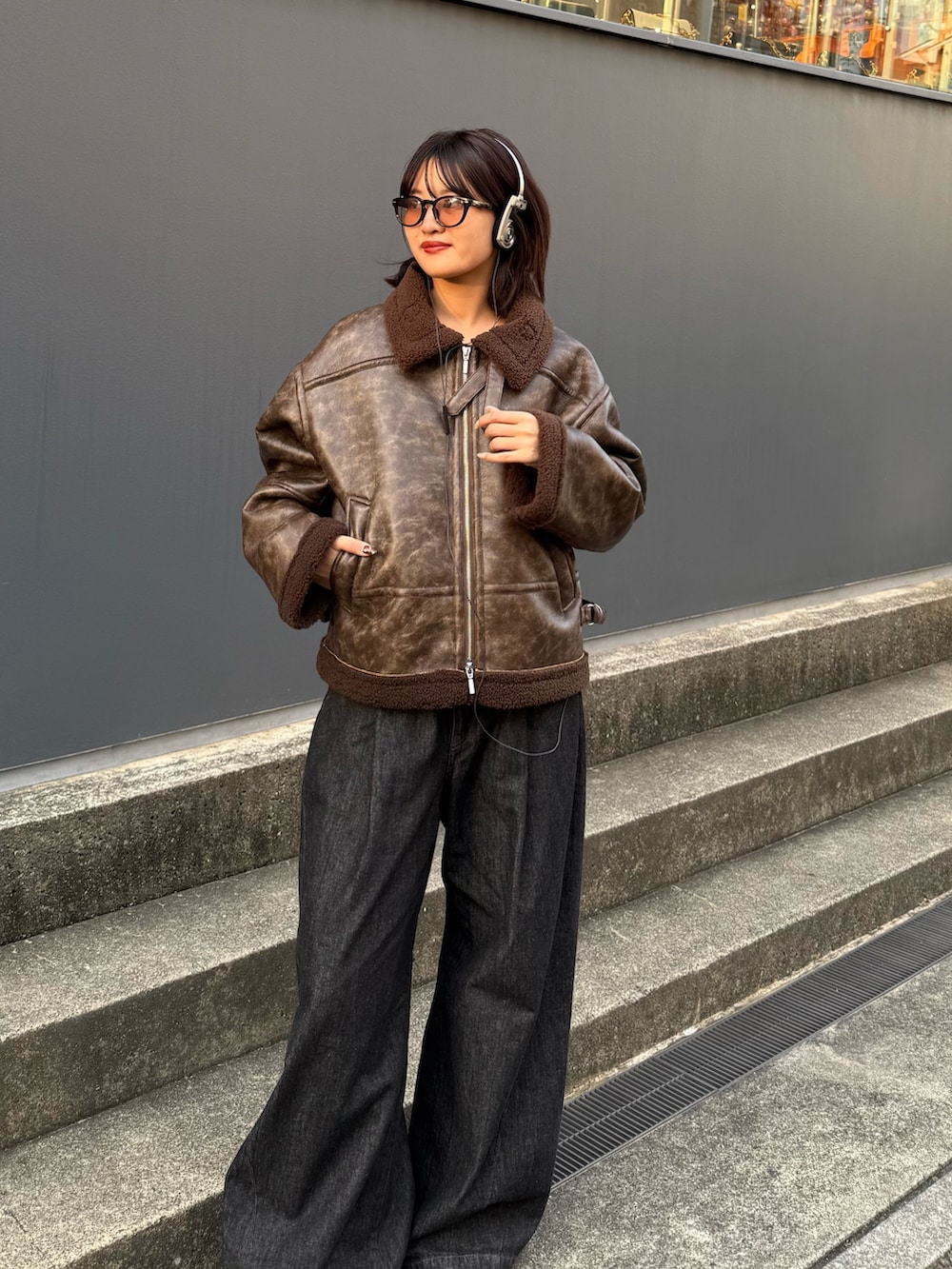 ブラウン系のブルゾン、ブラック系のデニムパンツを着用したレディースの秋コーディネートの8枚目の写真