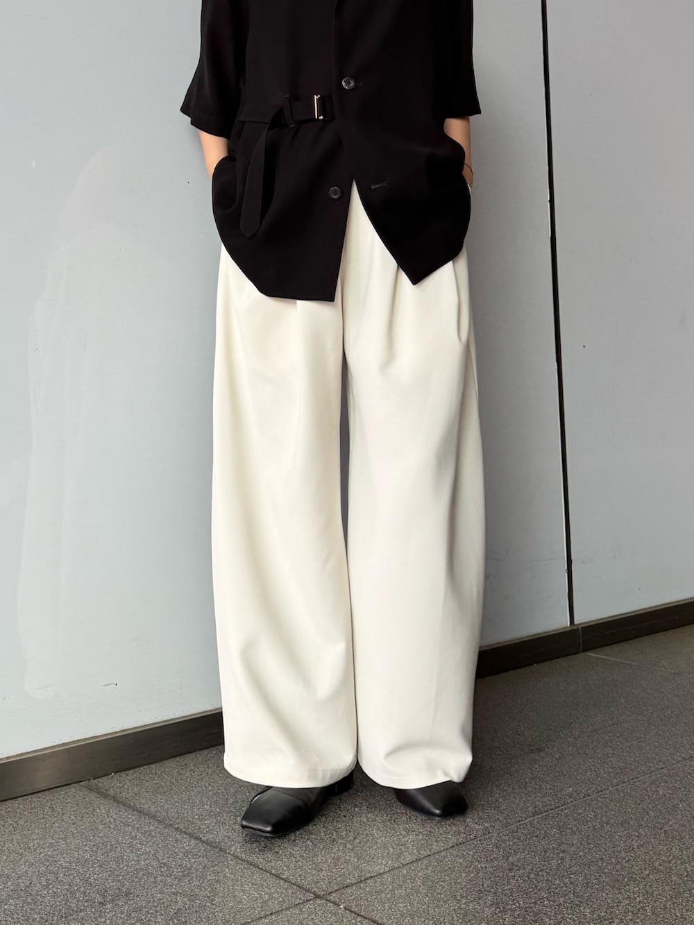 グレー系のスラックス、ブラック系のシャツ/ブラウスを着用したレディースの春コーディネートの6枚目の写真