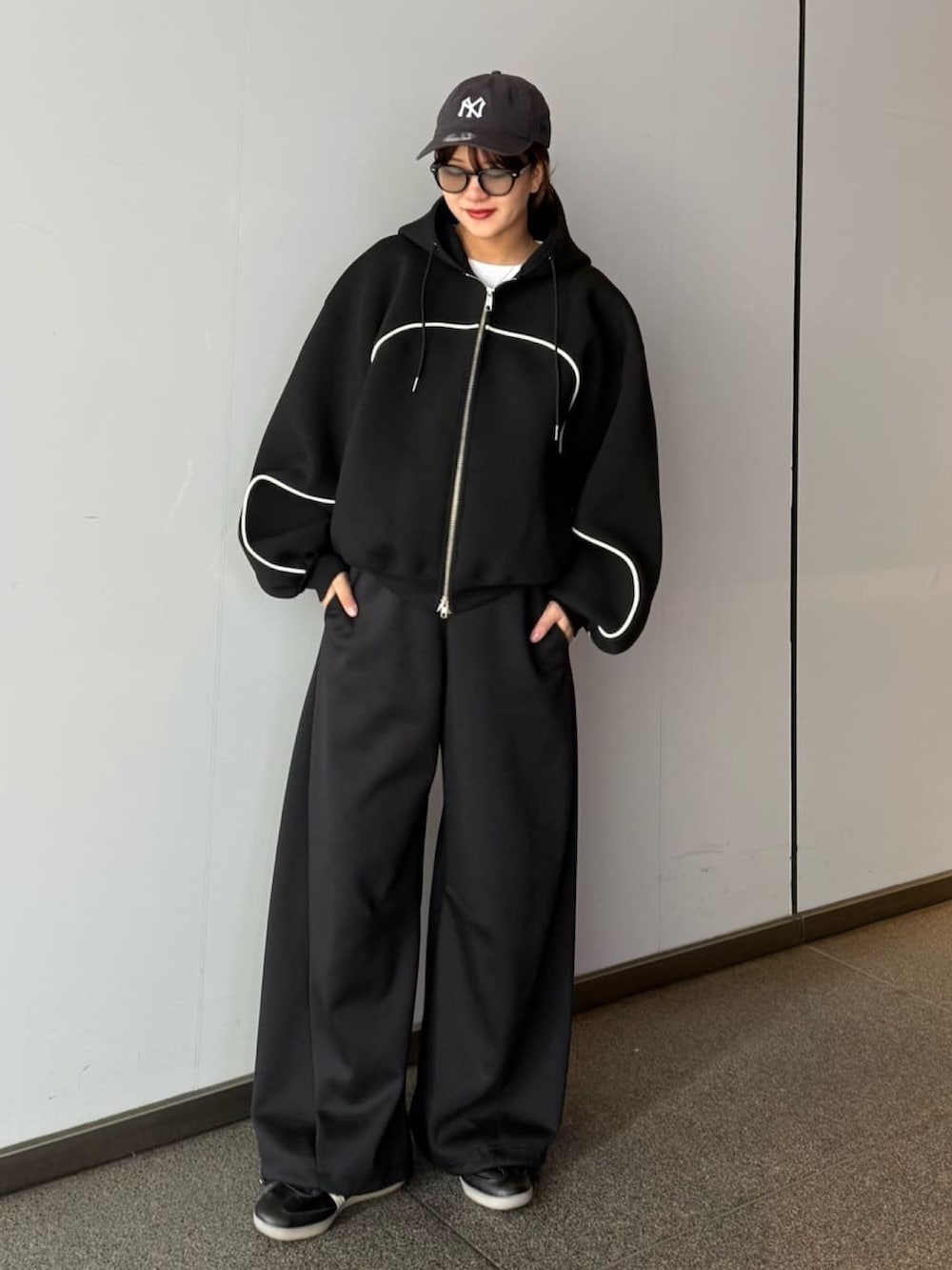 グレー系のその他パンツ、グレー系のパーカー、ブラック系のサングラスを着用したレディースの春コーディネートの4枚目の写真