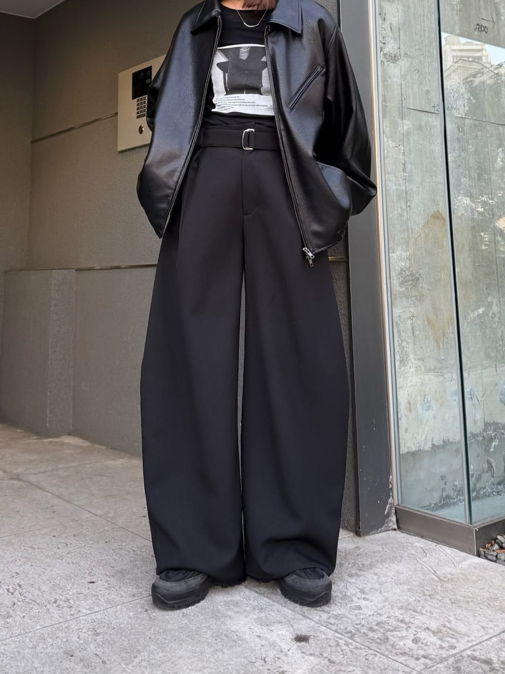 ブラック系のスラックス、ブラック系のブルゾン、ブラック系のTシャツ/カットソーを着用したレディースの冬コーディネートの5枚目の写真