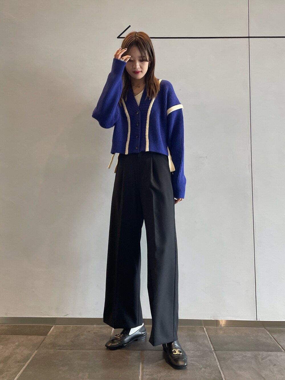 ホワイト系のキャミソール、ブルー系のカーディガン/ボレロ、ブラック系のその他パンツを着用したレディースの秋コーディネートの2枚目の写真