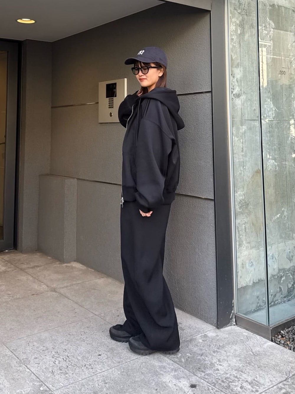 ブルー系のパーカー、ブラック系のスラックス、ブラック系のTシャツ/カットソーを着用したレディースの冬コーディネートの3枚目の写真