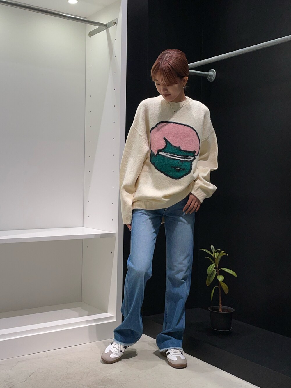 ホワイト系のニット/セーター、ブルー系のデニムパンツを着用したレディースの秋コーディネートの4枚目の写真