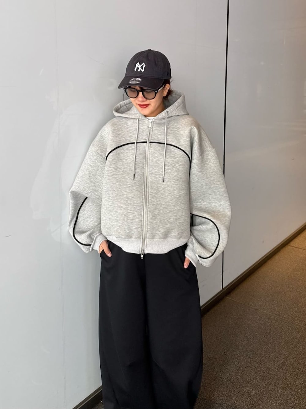 グレー系のパーカー、グレー系のその他パンツ、ブラック系のサングラスを着用したレディースの春コーディネートの5枚目の写真