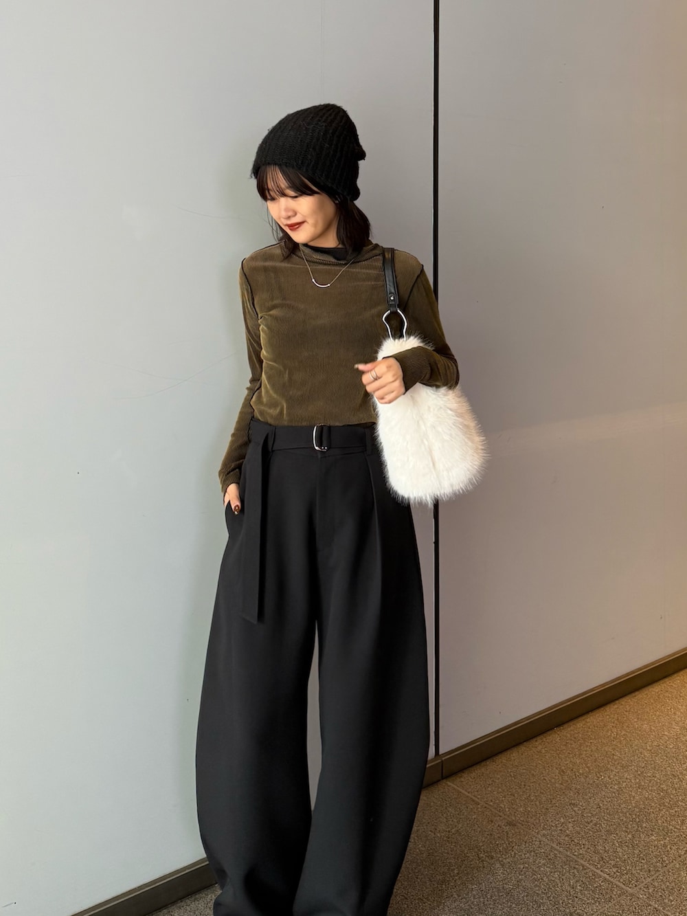 ブラック系のスラックス、ブラウン系のトートバッグ、グリーン系のTシャツ/カットソーを着用したレディースの秋コーディネートの2枚目の写真