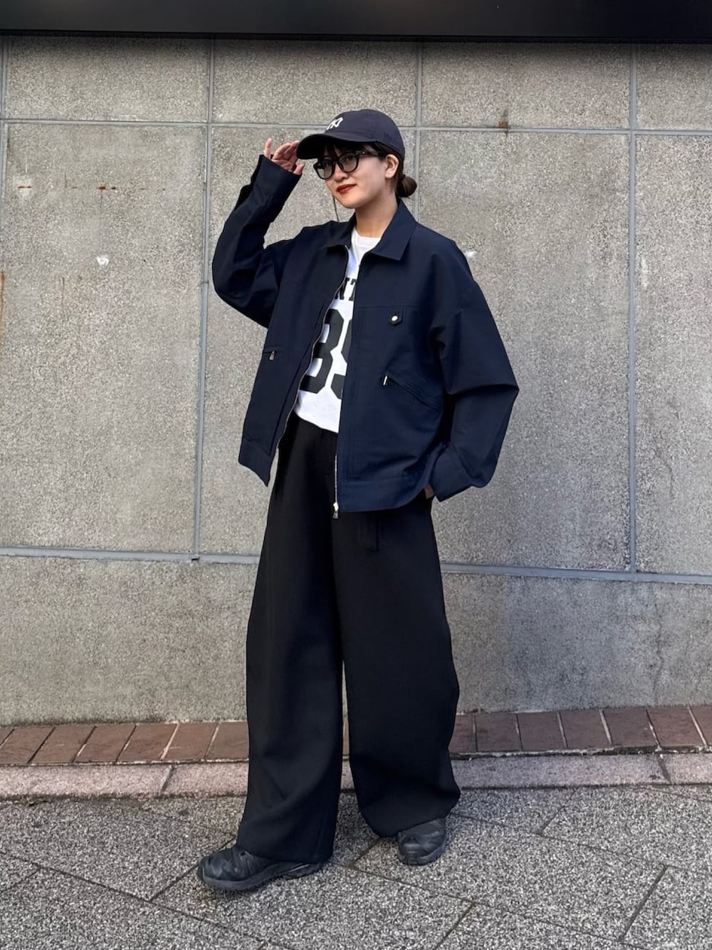 ブラック系のスラックス、ブルー系のブルゾン、ブラック系のサングラスを着用したレディースの冬コーディネートの8枚目の写真