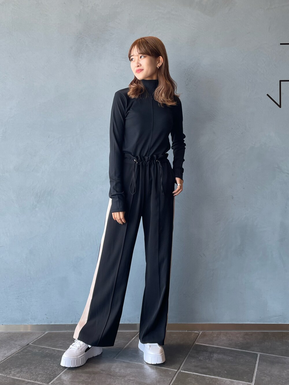 ブラック系のTシャツ/カットソー、ブラック系のその他パンツ、ホワイト系のスニーカーを着用したレディースの秋コーディネートの3枚目の写真