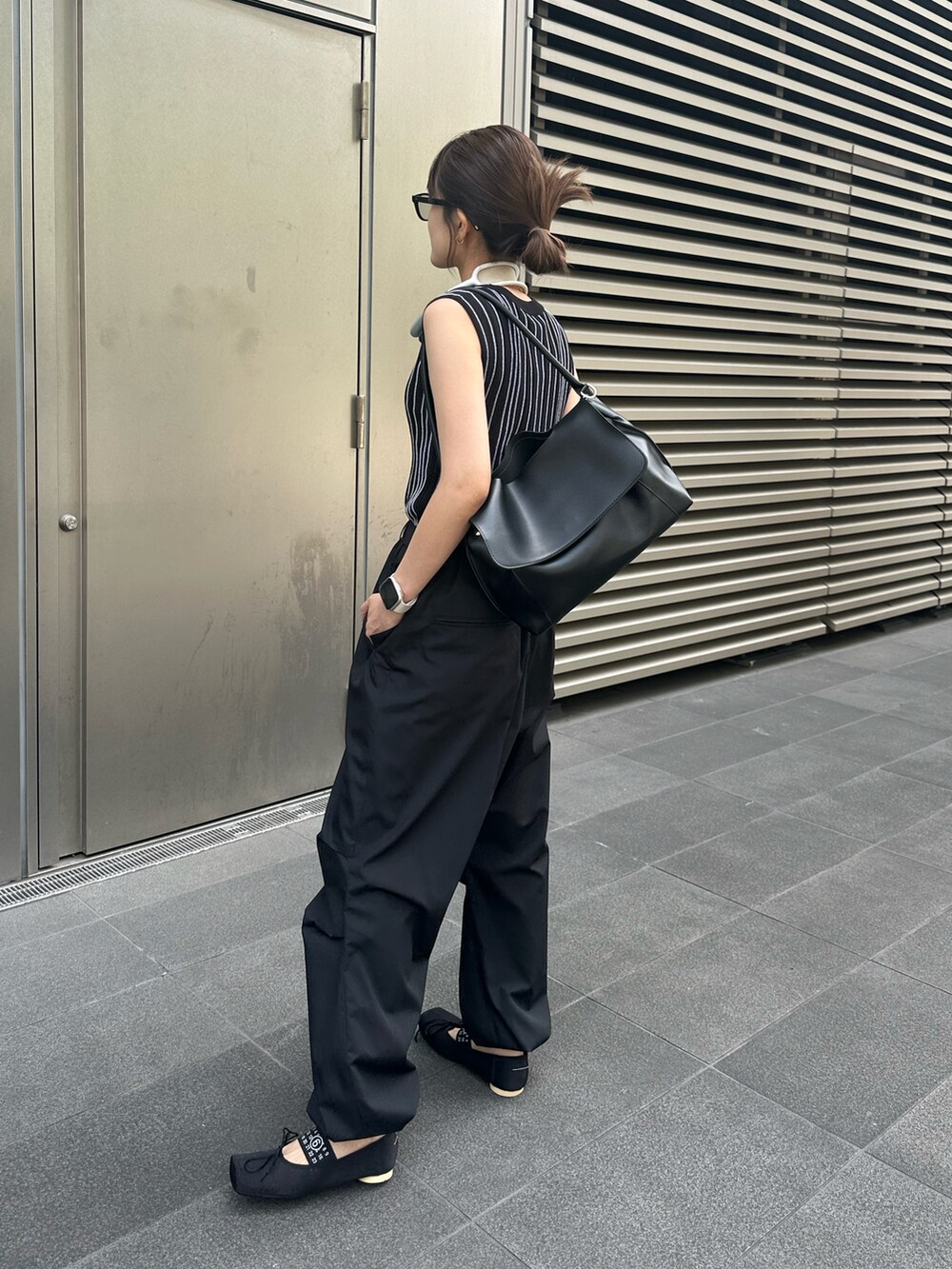 ブラック系のニット/セーター、ブラック系のカーゴパンツ、ブラック系のバレエシューズを着用したレディースの夏コーディネートの3枚目の写真