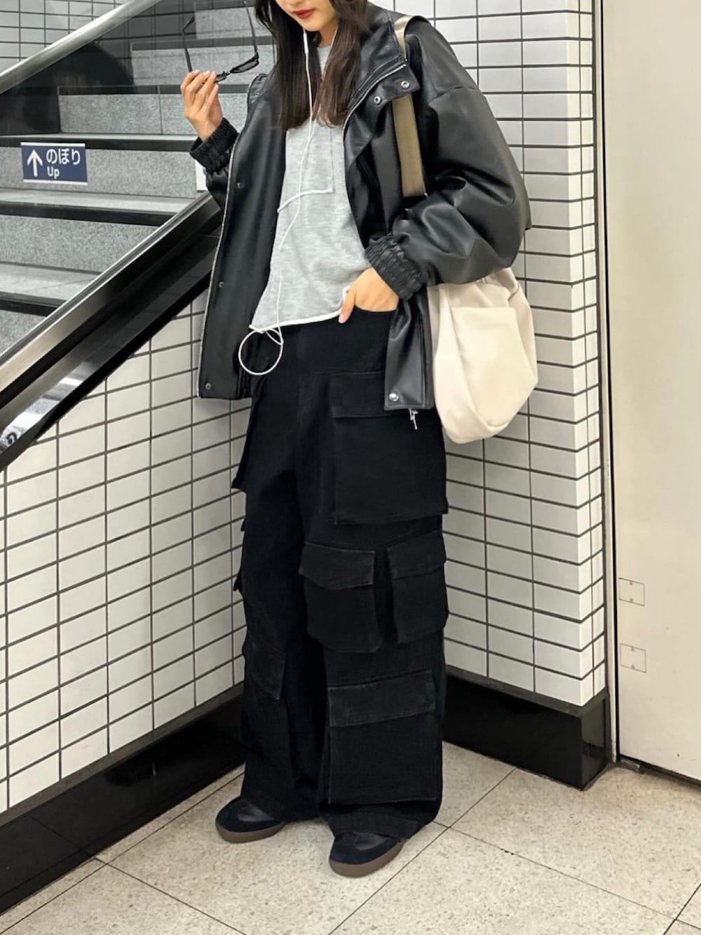 ホワイト系のショルダーバッグ、グレー系のトップス、ブラック系のジャケット/アウターを着用したレディースの冬コーディネートの2枚目の写真