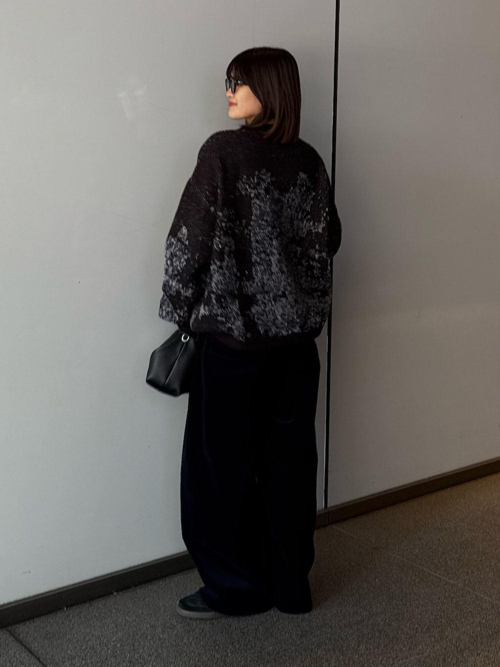 ブラック系のニット/セーター、ブラック系のトートバッグ、ブルー系のその他パンツを着用したレディースの秋コーディネートの3枚目の写真
