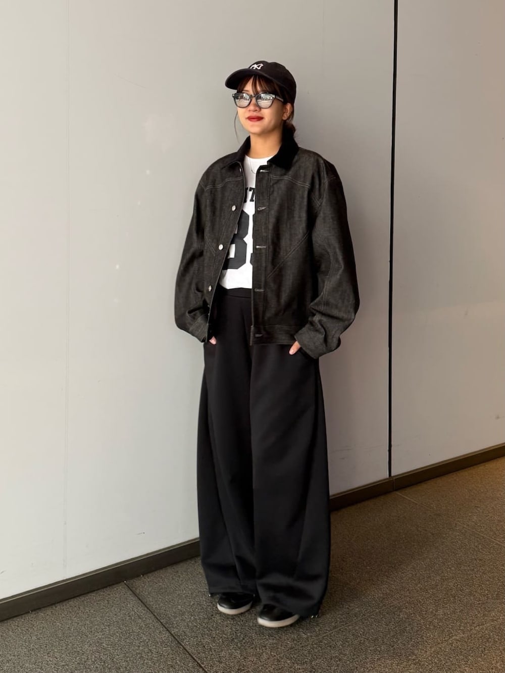 ブラック系のデニムジャケット、グレー系のその他パンツ、ブラック系のサングラスを着用したレディースの春コーディネートの4枚目の写真