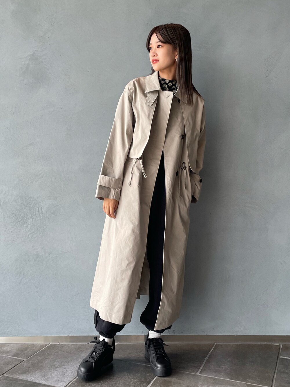 ベージュ系のシャツ/ブラウス、ベージュ系のトレンチコート、ブラック系のその他パンツを着用したレディースの秋コーディネートの2枚目の写真