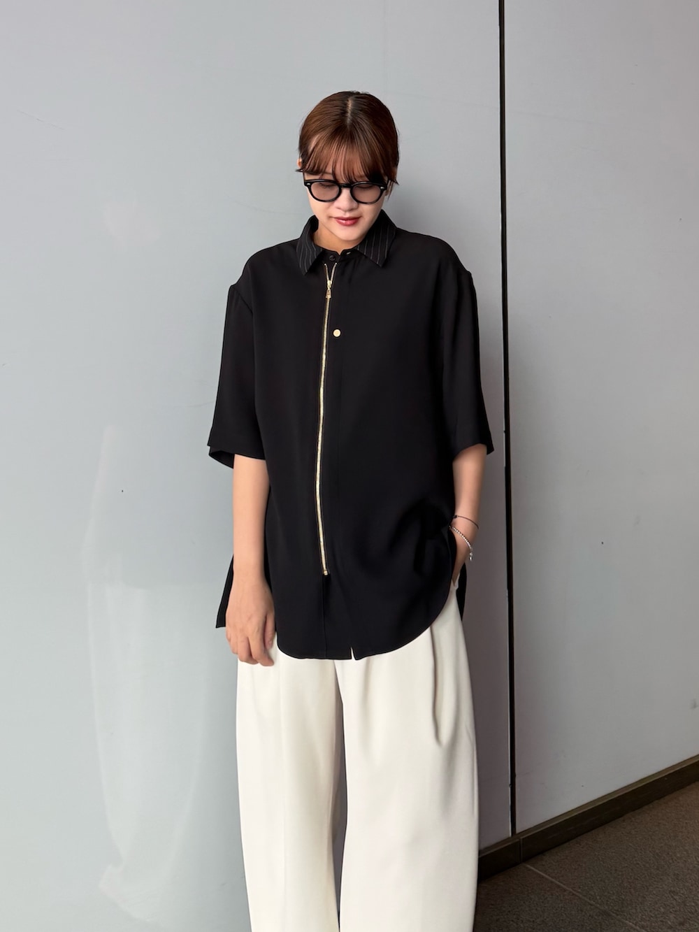 ブラック系のシャツ/ブラウス、グレー系のスラックスを着用したレディースの春コーディネートの5枚目の写真