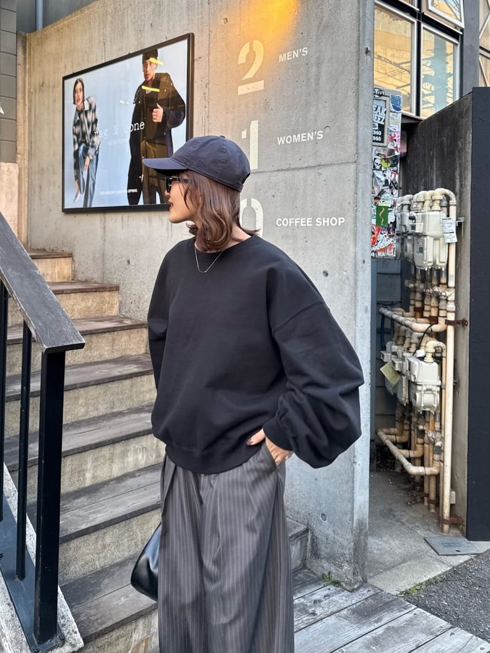 ホワイト系のスウェット、グレー系のスラックス、ブラック系のハンドバッグを着用したレディースの冬コーディネートの6枚目の写真