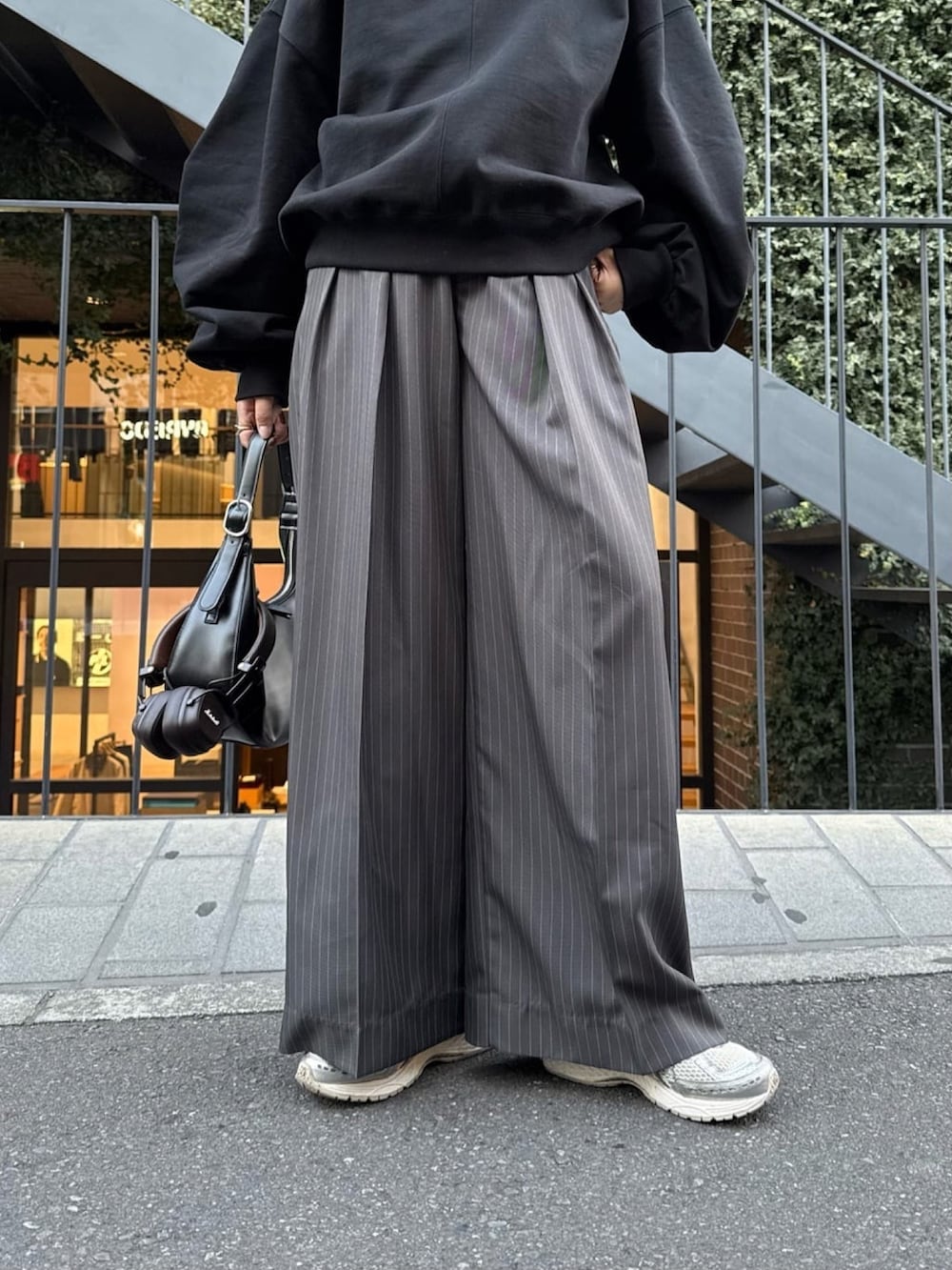 ホワイト系のスウェット、グレー系のスラックス、ブラック系のハンドバッグを着用したレディースの冬コーディネートの7枚目の写真