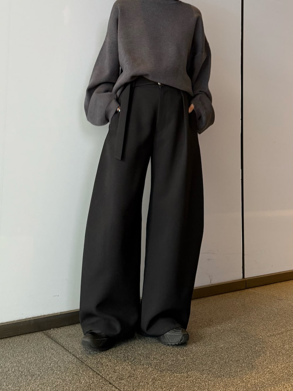 グレー系のニット/セーター、ブラック系のスラックス、ブラック系のサングラスを着用したレディースの秋コーディネートの7枚目の写真