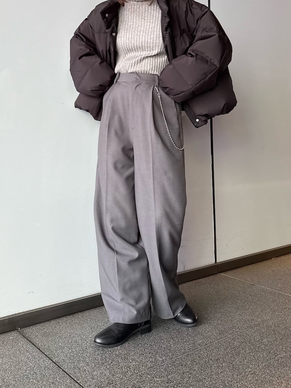 ホワイト系のダウンジャケット/コート、グレー系のスラックス、ブラック系のTシャツ/カットソーを着用したレディースの秋コーディネートの4枚目の写真