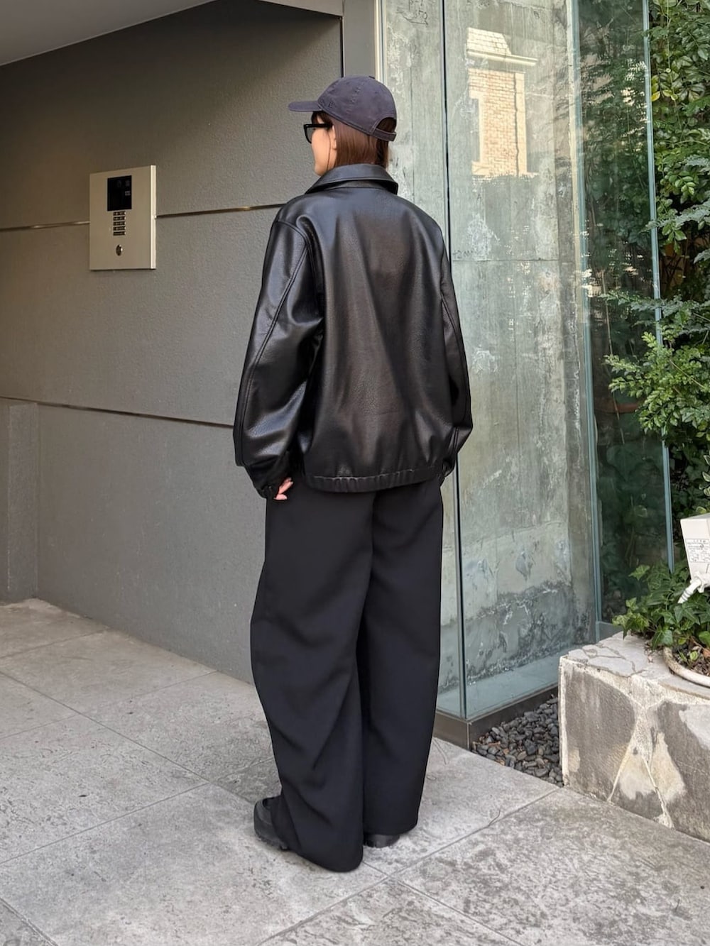 ブラック系のスラックス、ブラック系のブルゾン、ブラック系のTシャツ/カットソーを着用したレディースの冬コーディネートの4枚目の写真