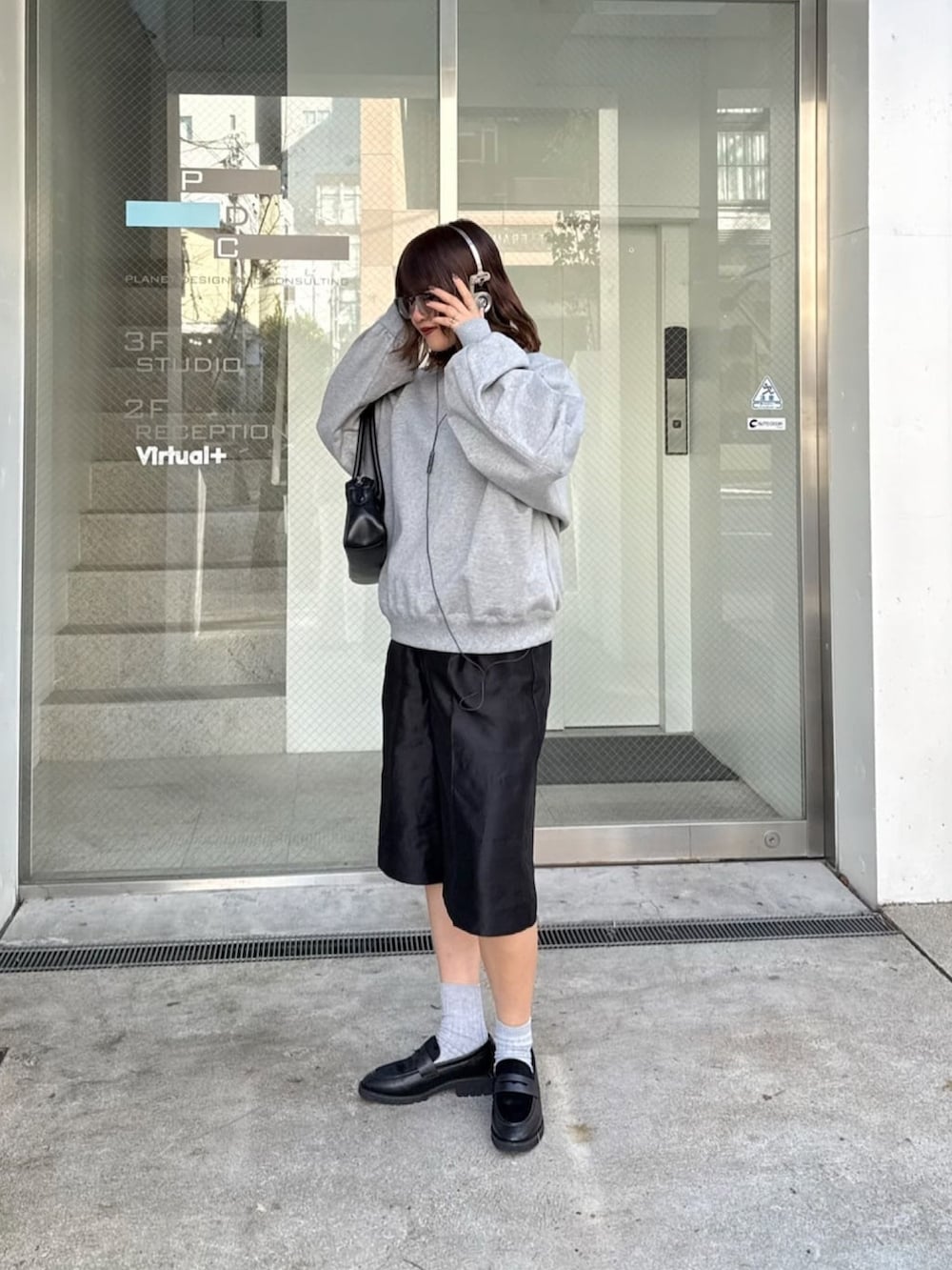 ホワイト系のスウェット、ブラック系のトートバッグを着用したレディースの冬コーディネートの6枚目の写真