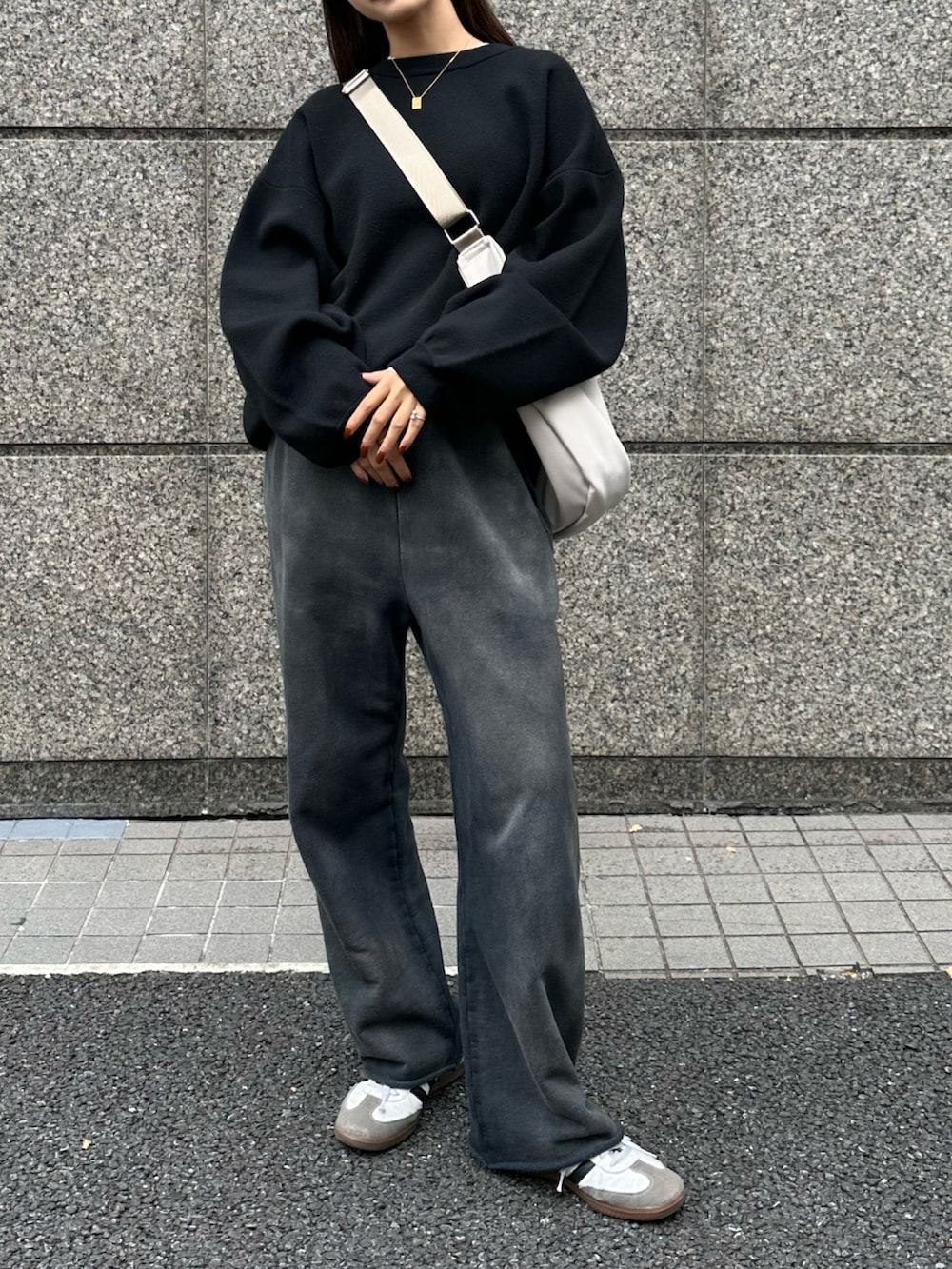 ホワイト系のバッグ、ホワイト系のスニーカー、ブラック系のニット/セーターを着用したレディースの秋コーディネートの4枚目の写真