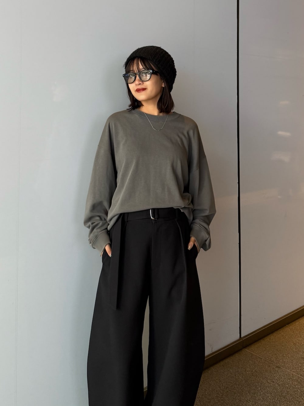 ブラック系のスラックス、ブラック系のスウェット、ブラック系のサングラスを着用したレディースの秋コーディネートの5枚目の写真