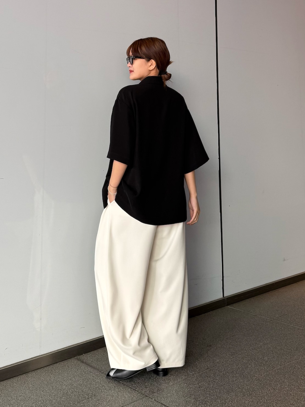 グレー系のスラックス、ブラック系のシャツ/ブラウスを着用したレディースの春コーディネートの4枚目の写真