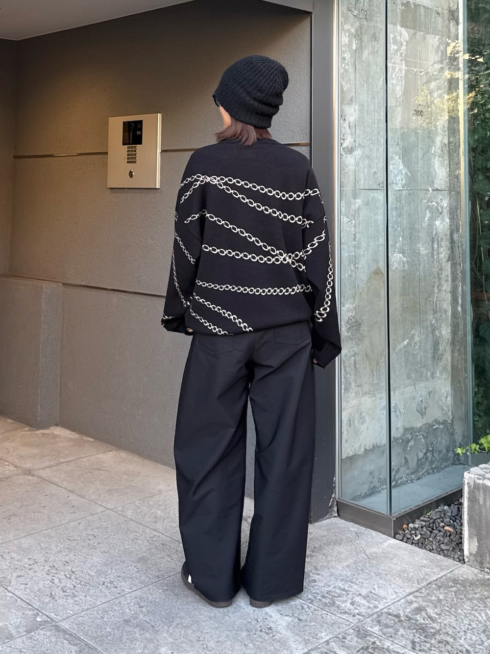 ブラック系のスラックス、ブラック系のニット/セーター、ブラック系のサングラスを着用したレディースの冬コーディネートの5枚目の写真