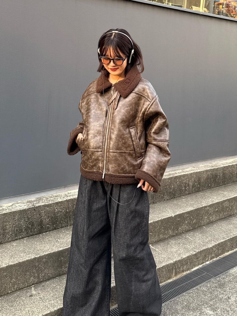 ブラウン系のブルゾン、ブラック系のデニムパンツを着用したレディースの秋コーディネートの7枚目の写真