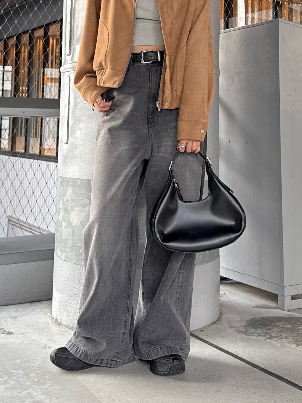 ブラウン系のブルゾン、ブラック系のデニムパンツ、ブラック系のベルトを着用したレディースの秋コーディネートの2枚目の写真