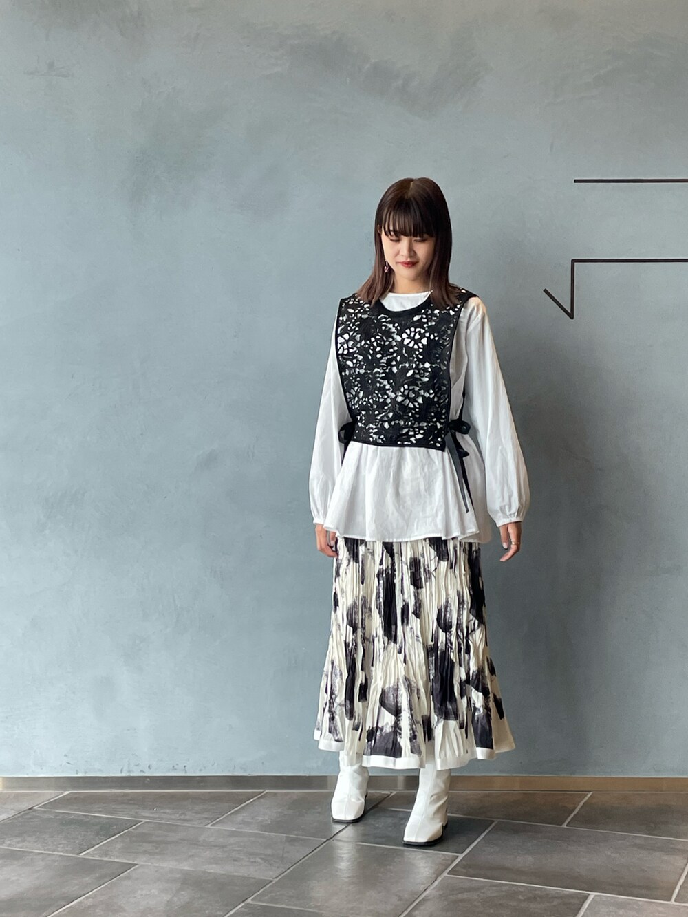 ブラック系のシャツ/ブラウス、ホワイト系のスカート、ホワイト系のブーツを着用したレディースの春コーディネートの3枚目の写真