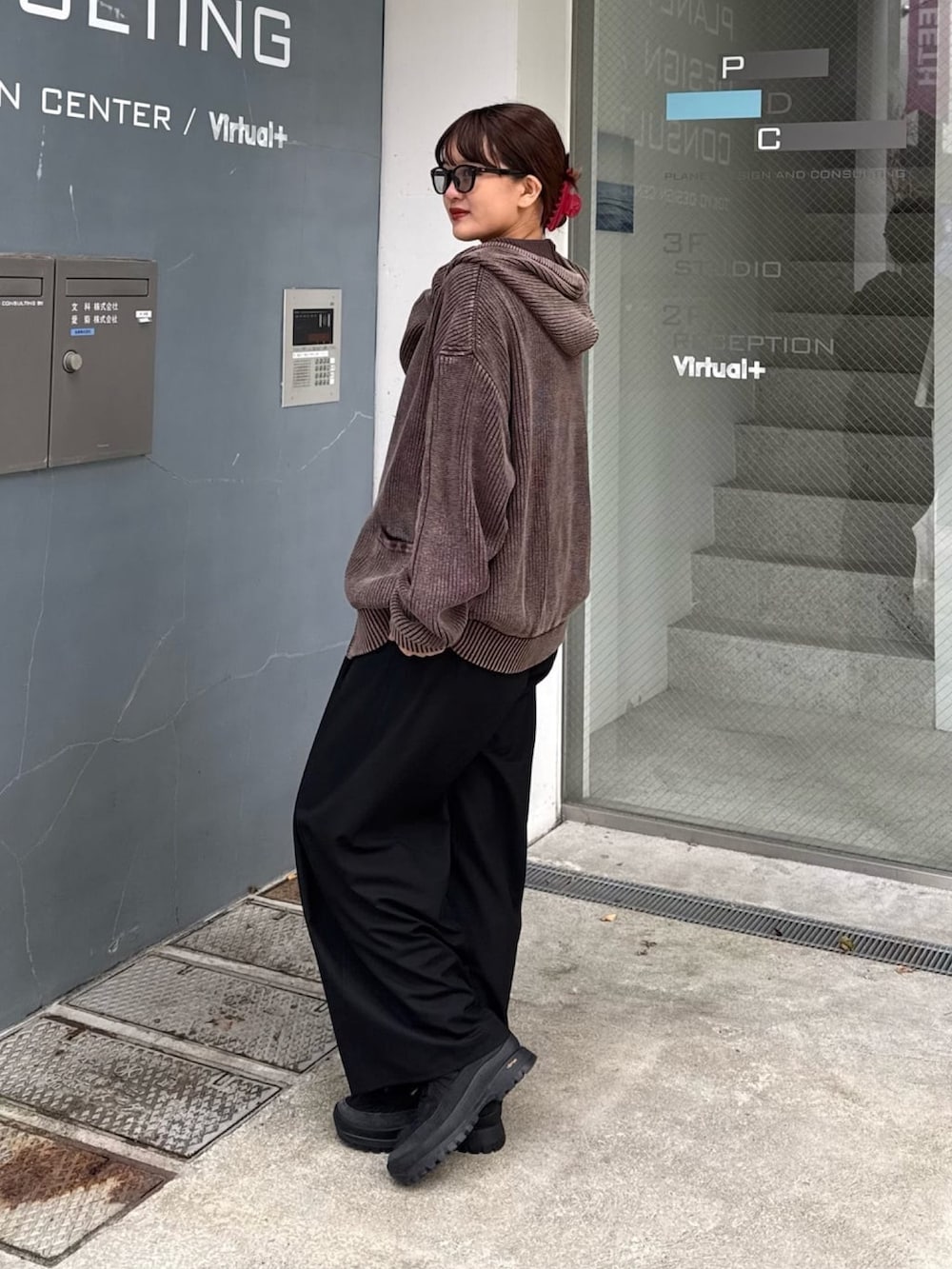 ブラウン系のパーカー、グレー系のスラックスを着用したレディースの春コーディネートの3枚目の写真