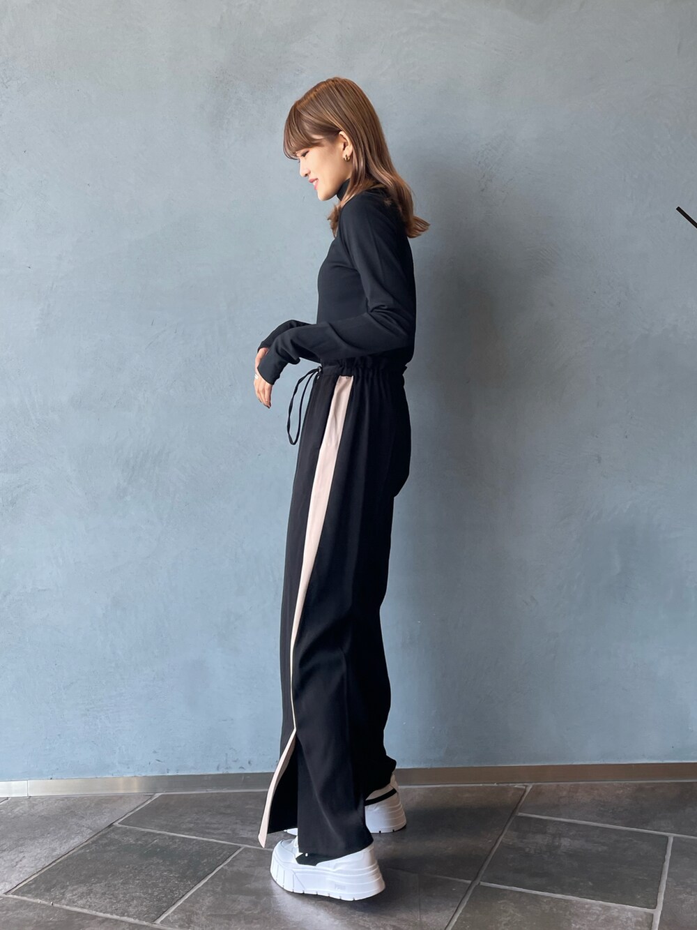 ブラック系のTシャツ/カットソー、ブラック系のその他パンツ、ホワイト系のスニーカーを着用したレディースの秋コーディネートの5枚目の写真