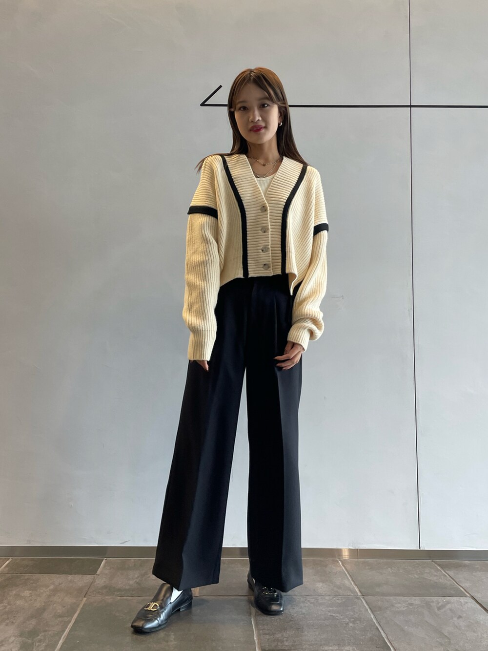 ホワイト系のカーディガン/ボレロ、ホワイト系のキャミソール、ブラック系のその他パンツを着用したレディースの秋コーディネートの2枚目の写真