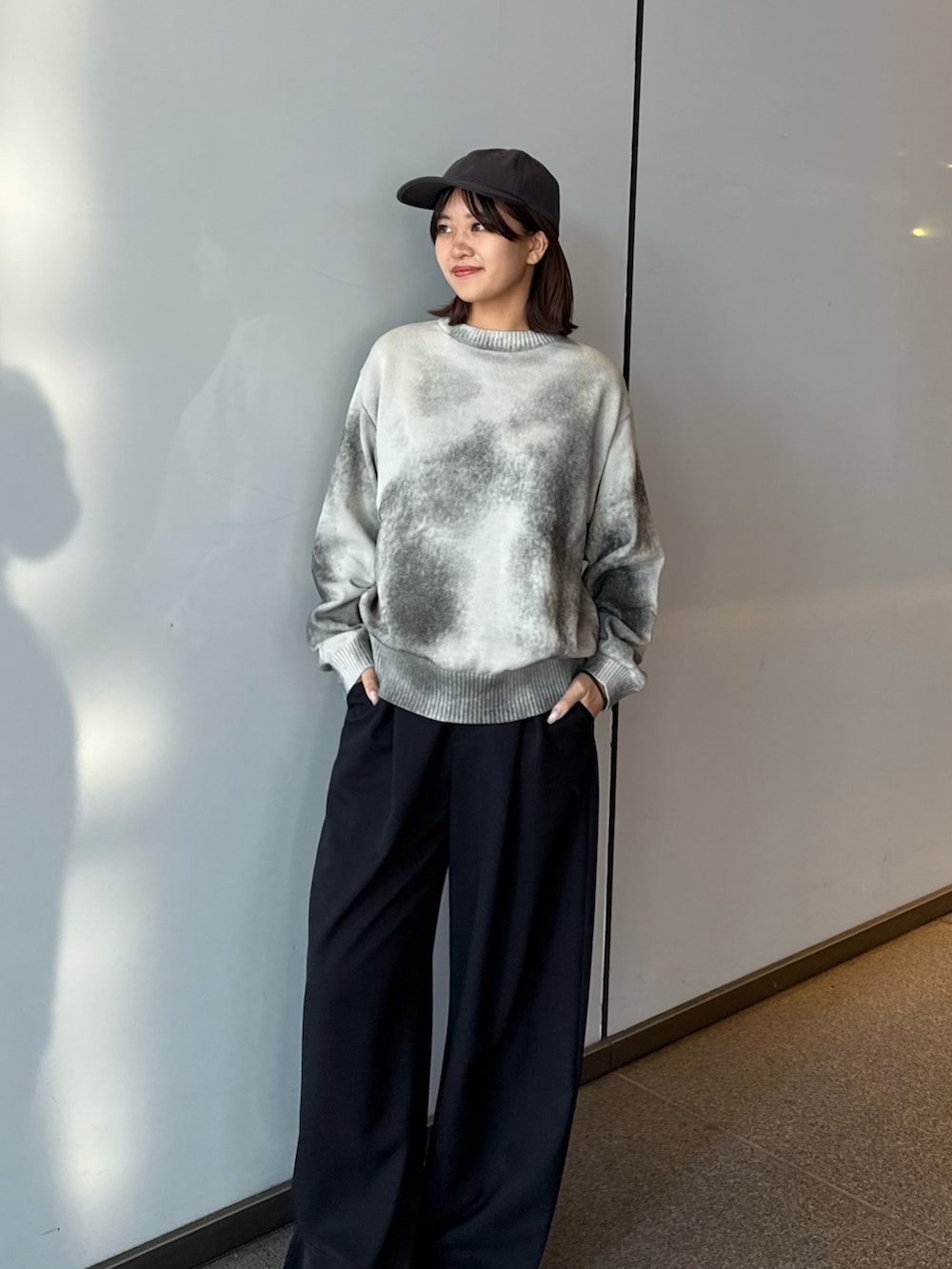 ホワイト系のニット/セーター、ブラック系のスラックスを着用したレディースの冬コーディネートの2枚目の写真