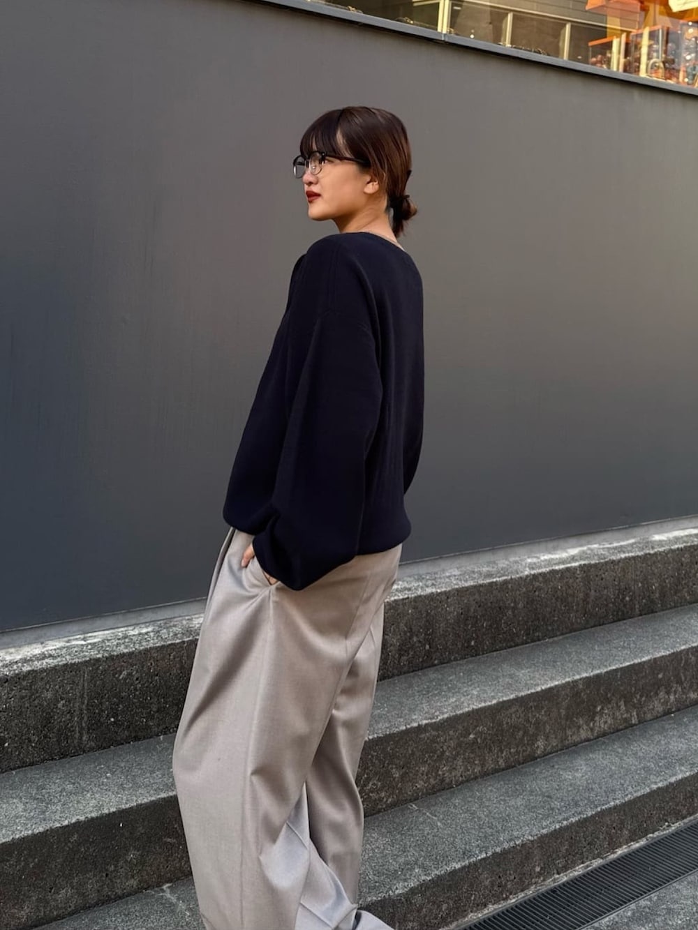 ブルー系のニット/セーター、グレー系のスラックスを着用したレディースの冬コーディネートの2枚目の写真