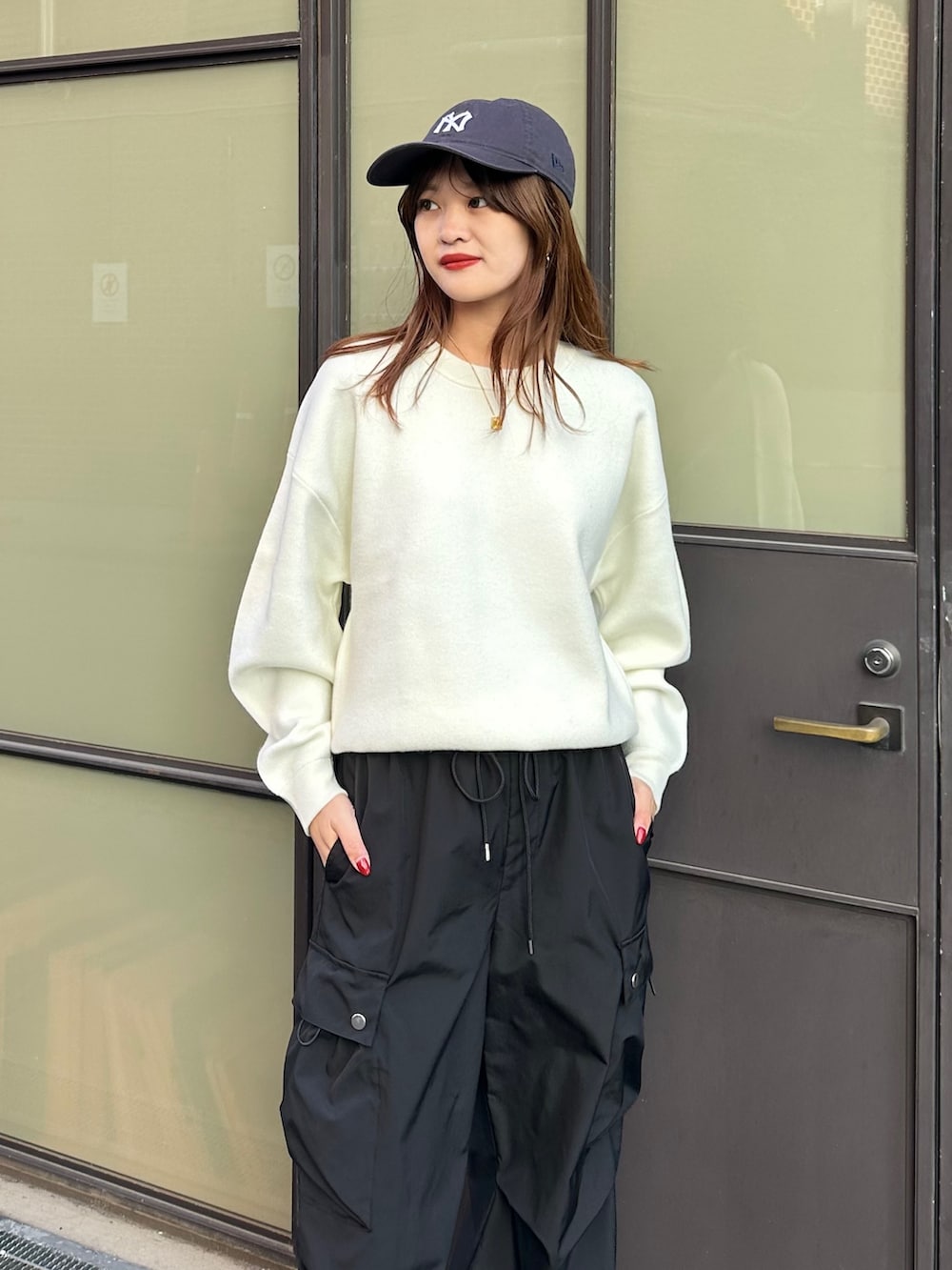 ホワイト系のニット/セーター、ブラック系のカーゴパンツを着用したレディースの冬コーディネートの2枚目の写真