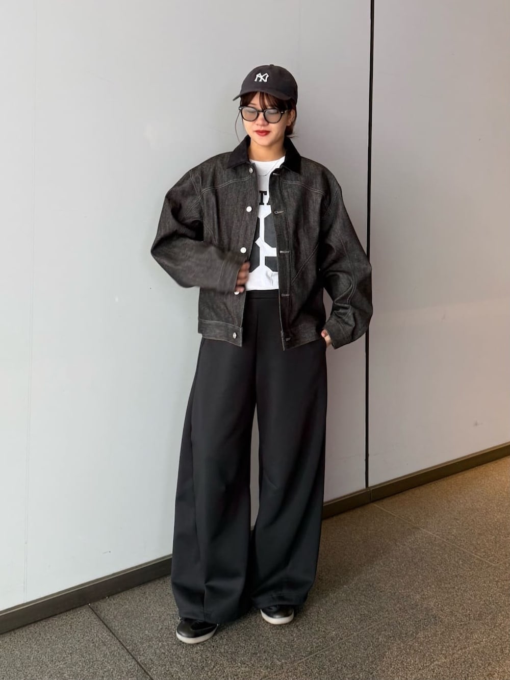 ブラック系のデニムジャケット、グレー系のその他パンツ、ブラック系のサングラスを着用したレディースの春コーディネートの3枚目の写真
