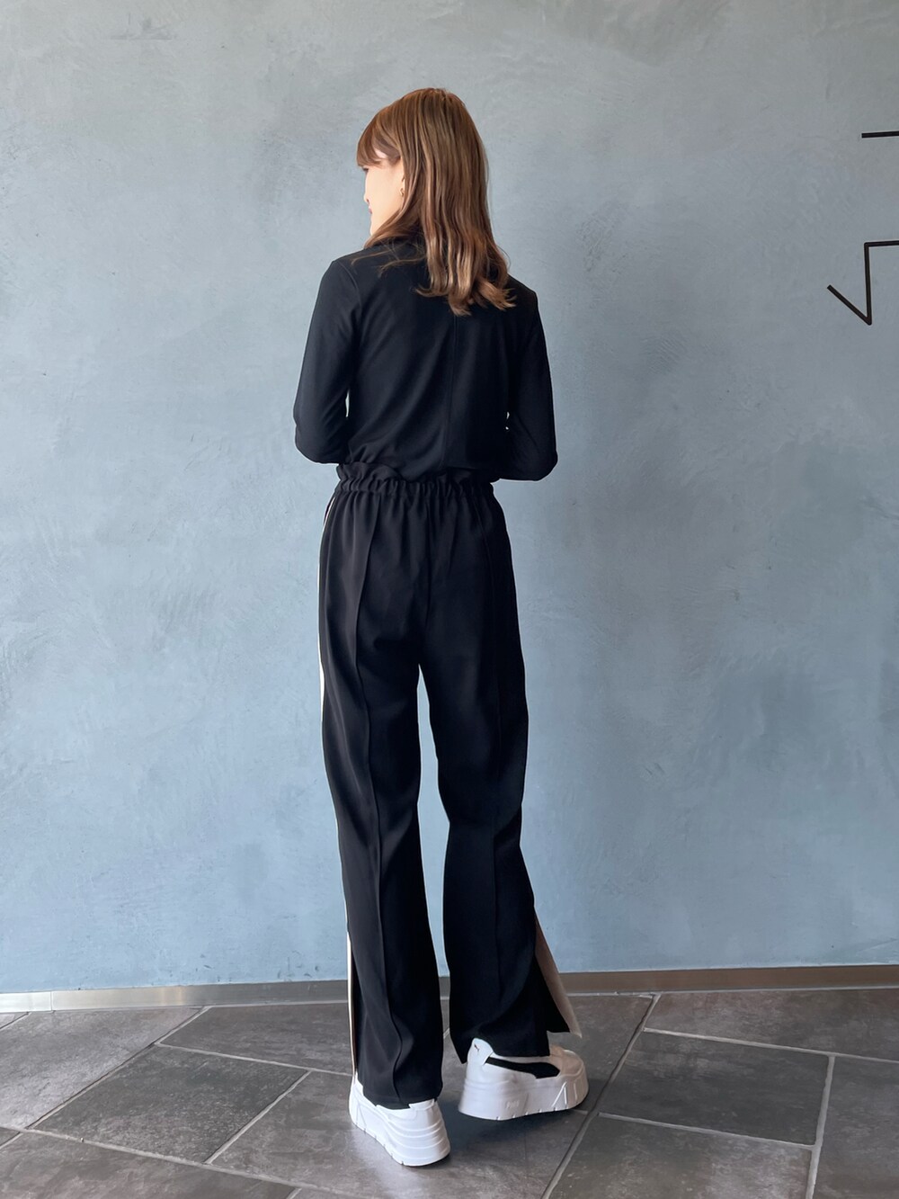 ブラック系のTシャツ/カットソー、ブラック系のその他パンツ、ホワイト系のスニーカーを着用したレディースの秋コーディネートの4枚目の写真