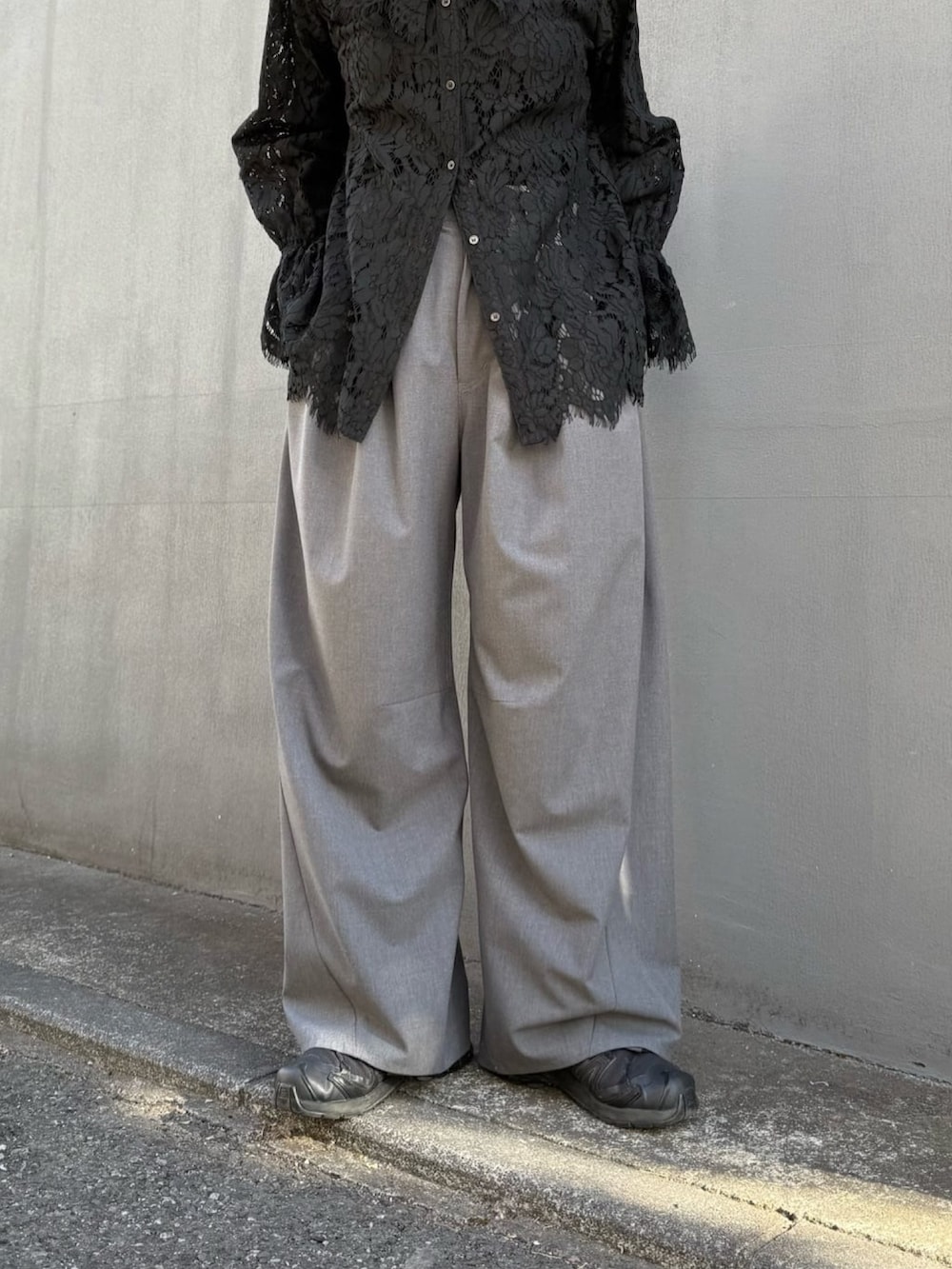 ブラック系のシャツ/ブラウス、グレー系のスラックスを着用したレディースの冬コーディネートの2枚目の写真