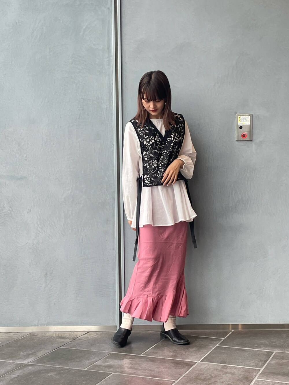 ブラック系のシャツ/ブラウス、ピンク系のスカート、ブラック系のパンプスを着用したレディースの春コーディネートの4枚目の写真