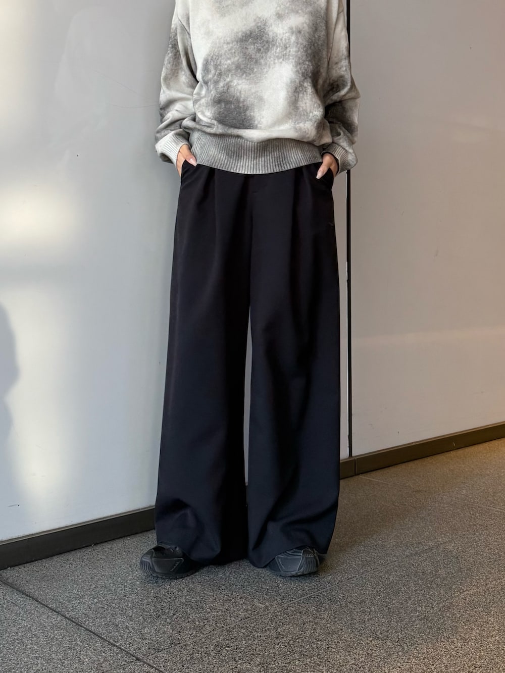 ベージュ系のブルゾン、ブラック系のスラックスを着用したレディースの冬コーディネートの5枚目の写真