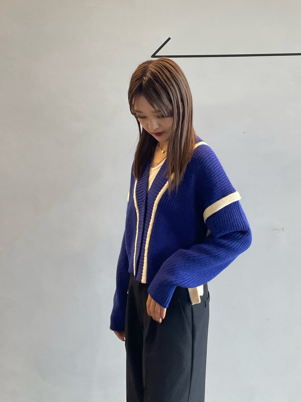 ホワイト系のキャミソール、ブルー系のカーディガン/ボレロ、ブラック系のその他パンツを着用したレディースの秋コーディネートの4枚目の写真