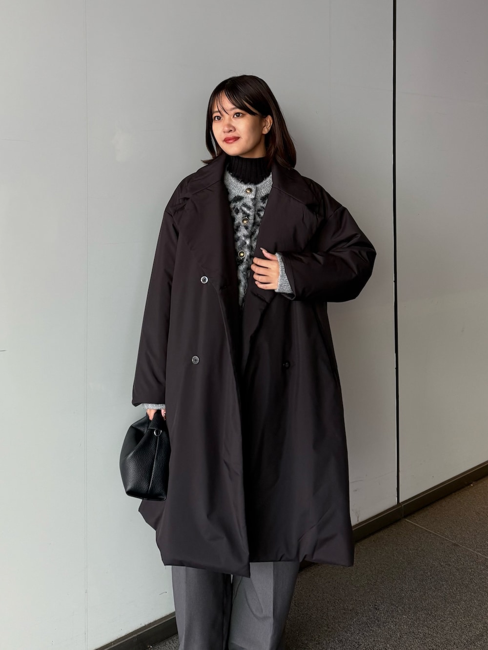ブラック系のカーディガン/ボレロ、ブラック系のチェスターコート、ブラック系のトートバッグを着用したレディースの秋コーディネートの4枚目の写真